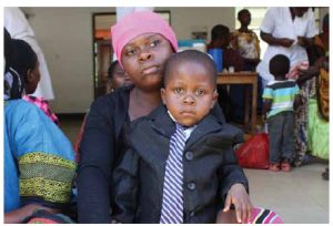 A mother brings her son to get immunized at a mobile health clinic in rural Morogoro,  Tanzania. Clinic staff provide information to mothers on how to make healthy choices when it comes to nutrition, hygiene and sanitation.