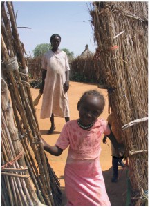 Sudan 2008: Villagers kept their compounds clean and debris-free using the type of homemade straw brooms this mother is carrying. This photograph was taken on one of our “show the UN flag” outback patrols. Jim Parker was in Sudan in 2008 as part of a UN observer mission. While there, the children stole his heart: “I encountered a wonderful variety of children: school and working children; children looking after their baby brothers and sisters; children in dirty ragged clothing and those in clean and pressed school uniforms; begging children and laughing children and children of nomadic families and others who lived in villages.”