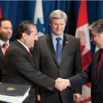 Prime Minister Stephen Harper, centre, watches as Trade Minister Peter Van Loan and Roberto Henríquez, Panama’s minister of commerce and industry, sign the Canada-Panama Free Trade Agreement.