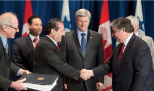 Prime Minister Stephen Harper, centre, watches as Trade Minister Peter Van Loan and Roberto Henríquez, Panama’s minister of commerce and industry, sign the Canada-Panama Free Trade Agreement.  