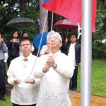 Jose S. Brillantes, ambassador of the Philippines, raises the flag at the 112th Anniversary of Philippine Independence on June 12 with the help of Joseph Angeles, minister and consul.