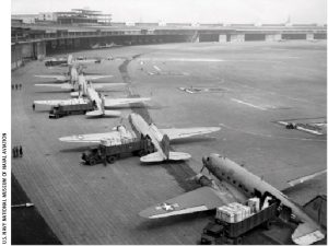 U.S. Navy Douglas R4D and U.S. Air Force C-47 aircraft unload at Tempelhof Airport during the Berlin Airlift circa 1948. 