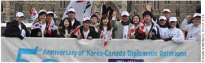 Koreans take part in the Rolling Rampage on Parliament Hill. Ambassador Nam Joo-hong is in the front row, centre, wearing a white ball cap with his hand in the air.