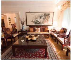 The living room is a simple, bright space, decorated with imposing Chinese rosewood chairs and tables.