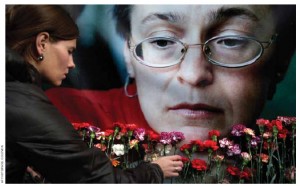 A woman places flowers before a portrait of Russian journalist Anna Politkovskaya, shot to death in her Moscow apartment building in 2006. 