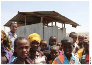 Misrak Dida Primary School students and headmaster stand before the newly constructed latrine facilities at their school.