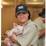 Sonya Fiorini, senior director for corporate social responsibility for Loblaw Companies, holds a piglet on a western Ontario farm.