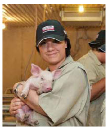 Sonya Fiorini, senior director for corporate social responsibility for Loblaw Companies, holds a piglet on a western Ontario farm.  