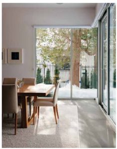 The dining room has windows on two sides, looking out onto the pretty lot.