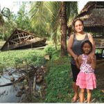 Jeniffer Inamarga and her daughter, Ruth, in front of their chicken coops. One coop was blown into a pond, drowning 600 birds and destroying this family’s livelihood.