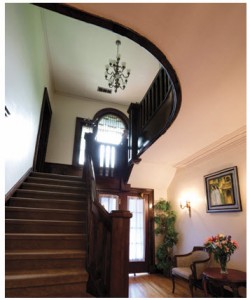 From the central hall, a wooden staircase leads to a tall, leaded-glass window before reaching the second floor and its six bedrooms. 