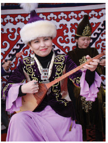 A woman at the Zheruik, an ethno-village in Astana, plays a traditional stringed instrument known as a dombra. (Photo: Ülle Baum)