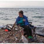 Nojeen, a16-year-old Syrian refugee, who uses a wheelchair due to a balance problem, waits to be lifted to the road. She and her older sister landed on the Greek island of Lesbos after crossing from Turkey, in hopes of finding better medical care. Greek authorities are looking after her. (Photo: © UNHCR/Ivor Prickett)