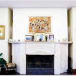 The centre of the reception area features a white marble fireplace and white furniture. A painting of horsemen with spears hangs over the mantel. (Photo: Ashley Fraser)