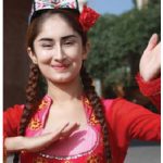 A dancer in brightly coloured traditional dress and handembroidered Uyghur flower hat performs for tourists visiting Kashgar. (Photo: Ülle Baum)