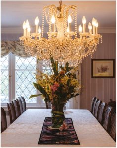 The dining room seats 20 and, while the chandelier strikes a formal, elegant note, the softly striped wallpaper adds warmth. (Photo: Dyanne Wilson)