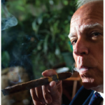 José Anselmo López Perera lights a fine Cuban cigar in the residence's smoking room. (Photo: Ashley Fraser)