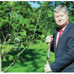Latvians in Canada celebrated their native country’s centenary by planting a red oak at Strathcona Park. Shown is Ambassador Kãrlis Eihenbaums doing the honours. (Photo: Ülle Baum)