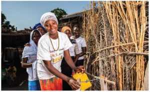 Amy Mandiang demonstrates the use of the ‘tippy tap,’ which dispenses clean water and soap for handwashing and is used in areas without running water. 