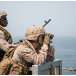 American naval personnel provide security aboard the amphibious dock landing ship USS Harpers Ferry during a Strait of Hormuz transit.