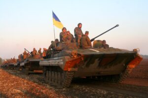  Ukrainian troops on armored vehicles flying the national flag during a military operation.